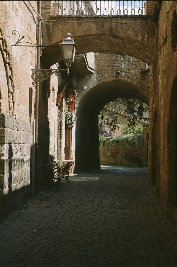 Tan arches and cobblestone walkway in Italy